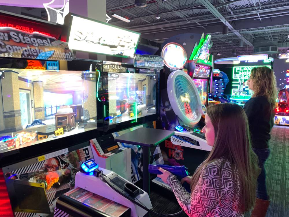 Two alumni playing arcade game